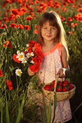 The girl in the field is holding a poppy