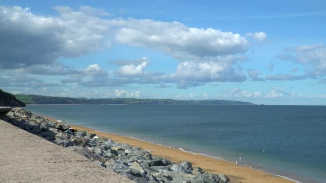 Beach in Beesands a small fishing village on the Devon coast. 4k footage of seagulls enjoying the waves and calm sea water on a bright and sunny day. UK travel destination in South West Devon