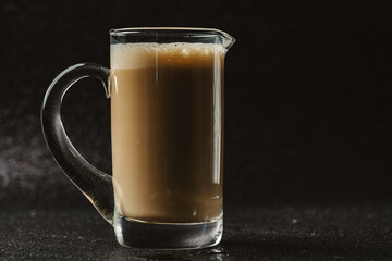Hot coffee is placed on a black background.