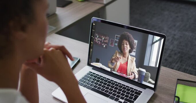 Mid Section Of African American Woman Having A Video Call On Laptop With Female Colleague At Office