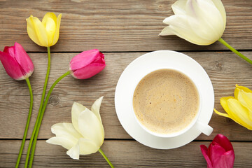 Obraz na płótnie Canvas Cup of coffee with tulips on grey wooden background