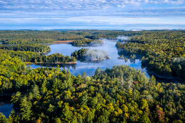 Aerial view of a misty lake with islands and forest © Paul