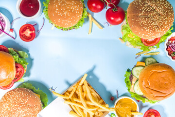 Fastfood, burger party concept. Various delicious burgers set with french fries and sauces on bright blue background flatlay top view copy space