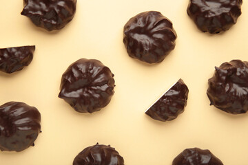 Chocolate covered marshmallows on beige background. Minimalism