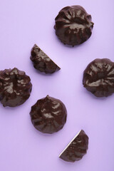 Chocolate covered marshmallows on purple background. Minimalism