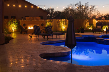 A high definition view of a desert landscaped backyard in Mesa Arizona, with a pool spa, outdoor fireplace and Kitchen.