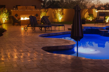 A high definition view of a desert landscaped backyard in Mesa Arizona, with a pool spa, outdoor fireplace and Kitchen.