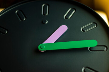 Close up shot of a clock with colorful hands.Indoors