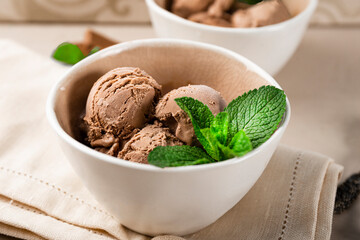 Balls of homemade chocolate ice cream with mint in a bowl close up