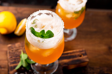 A glass of cold beer with lemon and mint, traditional latin american drink michelada on the table...
