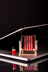 Beach chairs isolated inside a laptop on black background