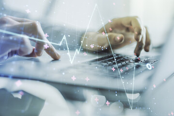 Creative concept of heart pulse illustration and hands typing on laptop on background. Medicine and...