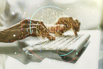 Creative artificial Intelligence concept with human brain hologram and hands typing on laptop on...