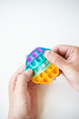 The most fashionable sensory toy. Popular fashion silicone colorful anti-stress hexagonal pop it toy. Someone presses on a silicone toy. A trendy toy for children.