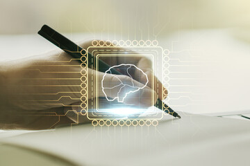 Double exposure of creative artificial Intelligence symbol with man hand writing in notebook on background. Neural networks and machine learning concept