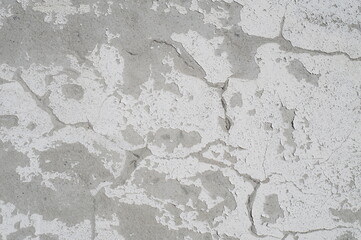 Photo of the wall surface. The wall decoration was partially destroyed, the white paint partially crumbled, the plaster layer cracked.