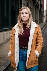 Portrait of young woman looking to camera in a narrow street.