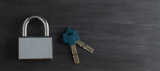 Candado de alta seguridad cerrado, color plata con un juego de llaves sobre un fondo color gris