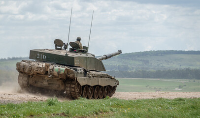 A British army Challenger 2 ii FV4034 Main Battle Tank travelling at speed in action on a military exercise, Wiltshire UK