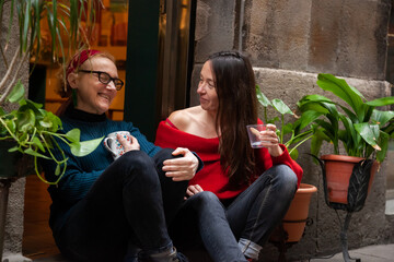 Obraz premium Two female friends sitting together in trendy city neighborhood