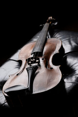 A viola or violin on a leather bench in a moody environment