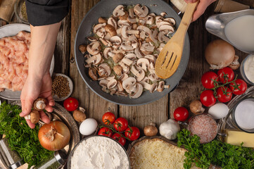 Mushrooms prepared for frying in a pan. Wooden spoon. Bright paint ingredients. Wooden table. Beautiful still life. Healthy vegetables. View from above.