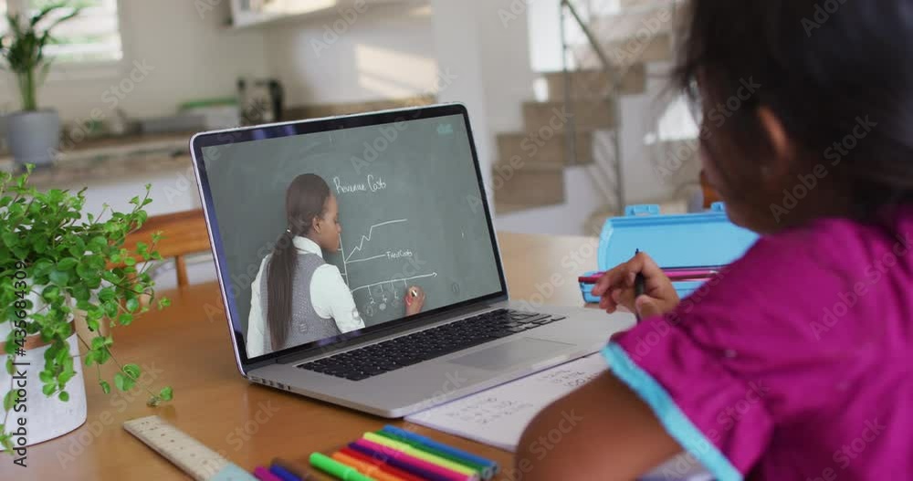 Canvas Prints African american girl doing homework while having a video call with female teacher on laptop at home