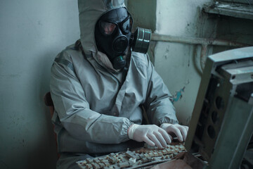 Scientist dosimetrist (radiation supervisor) in protective clothing and gas mask explores the...