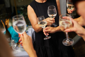Glasses in the hands of a company of people. The girl has a glass in her hands. 