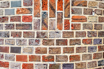 Old masonry of multicolored bricks in different shades of red and black