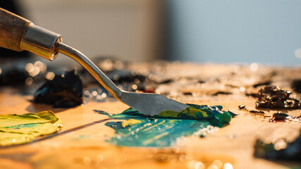 Artist work. Painting art. Professional craft. Spatula mixing blue yellow black oil or acrylic...