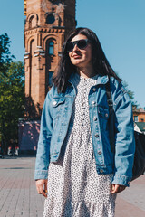 Portrait of brunette woman in sunglasses and jean jacket