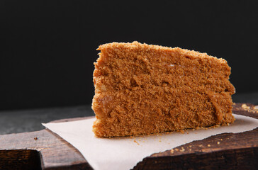 1 piece of honey cake on the board side view, dessert
