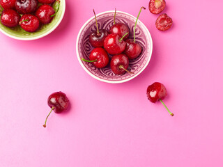 Bowl of fresh cherries on a pink background