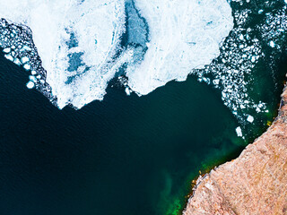 Melting ice floes on the shore of Baikal lake in spring. Aerial drone view. Baikal lake, Siberia,...