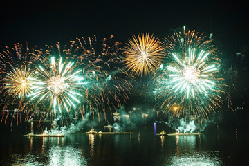 Holiday fireworks above water with reflection on the black sky background
