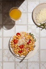 Carbonara pasta, mac and cheese on a plate on a tile table with parmesan