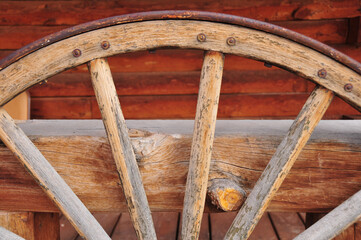 Fototapeta na wymiar Old western wagon wheel against a wooden bannister in Utah