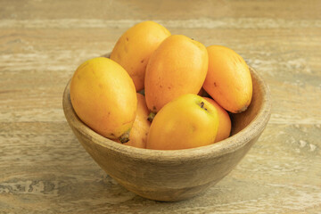 Loquat fruits on wooden background.