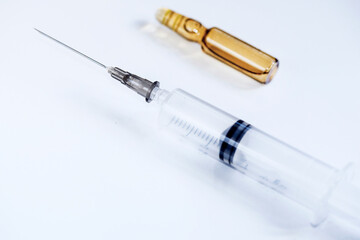 A syringe and a transparent flacon  on a white  background, close up, isolated