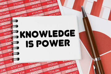 On financial documents and charts there is a notebook with the inscription - KNOWLEDGE IS POWER