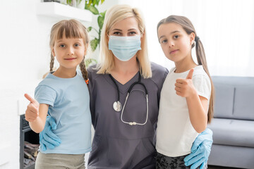 doctor with a stethoscope checks two little girls