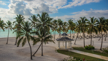 Fototapeta na wymiar plaża nad oceanem ,nad morzem karaibskim na Dominikanie w miejscowości Can Cana z przepięknym widokiem palm,oceanu i altanki ślubnej