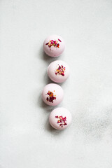 Bath bombs with rose petals on gray neutral background