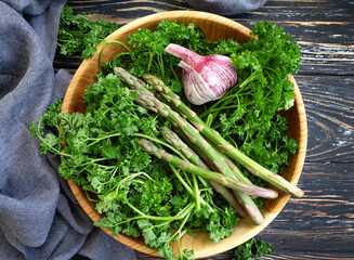 asparagus, parsley on a wooden background
