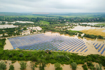 Aerial view of flooded solar power station with dirty river water in rain season.