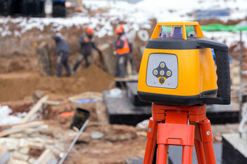 Laser rangefinder at a construction site. Measuring tool at a construction site. Accurate construction site measurement equipment