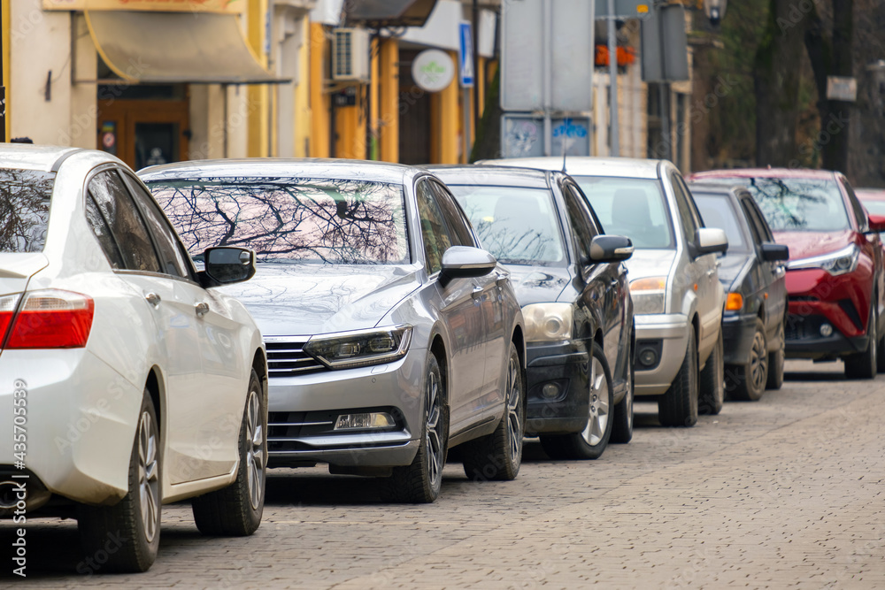 Sticker Cars parked in a row on a city street side.