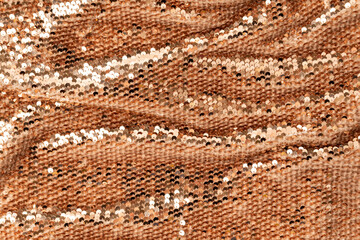 Golden shiny background, fabric background with sparkle. Sequins on the textile with folds