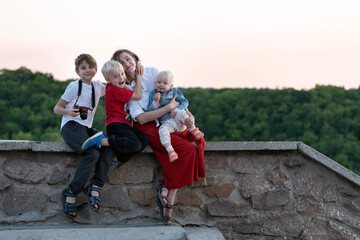 Mother and three children have fun on nature background. Vacation with children.